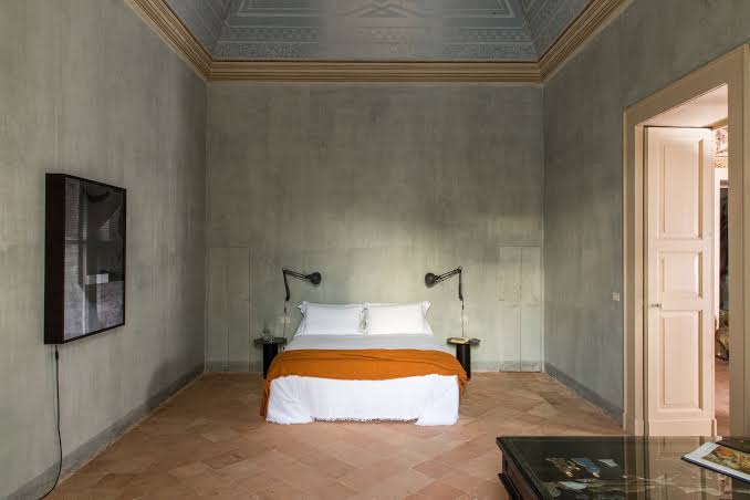 High-ceilinged bedroom with terracotta floor at Palazzo Daniele, Gagliano del Capo, Italy