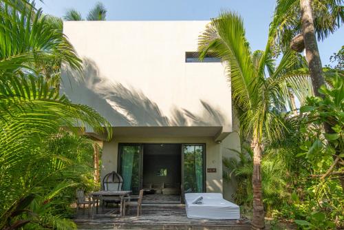 White cubic villa among palms at Casa Malca in Tulum, Mexico