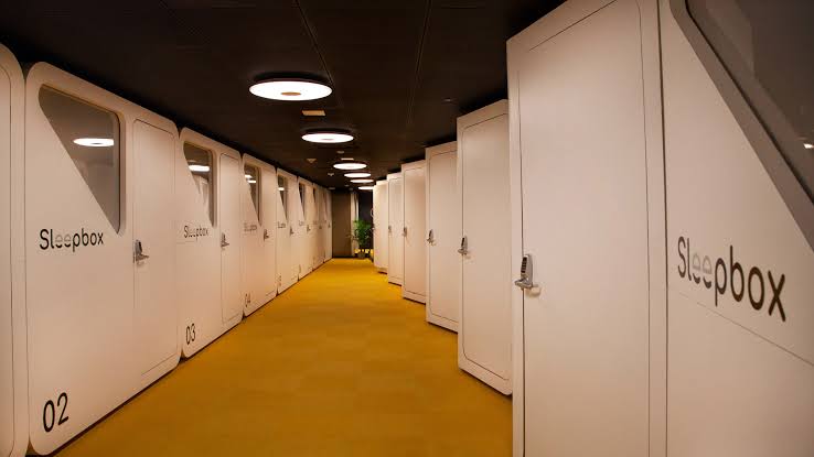 White Sleepbox cabins along a yellow corridor at Washington Dulles International Airport